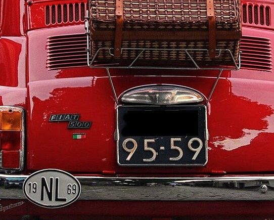 Rotes Auto in einer Baumallee